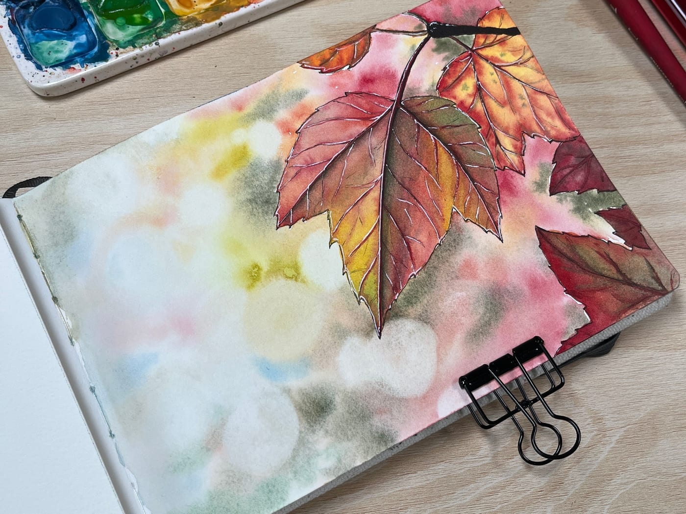 Watercolour of autumn leaves falling against a soft blurred background