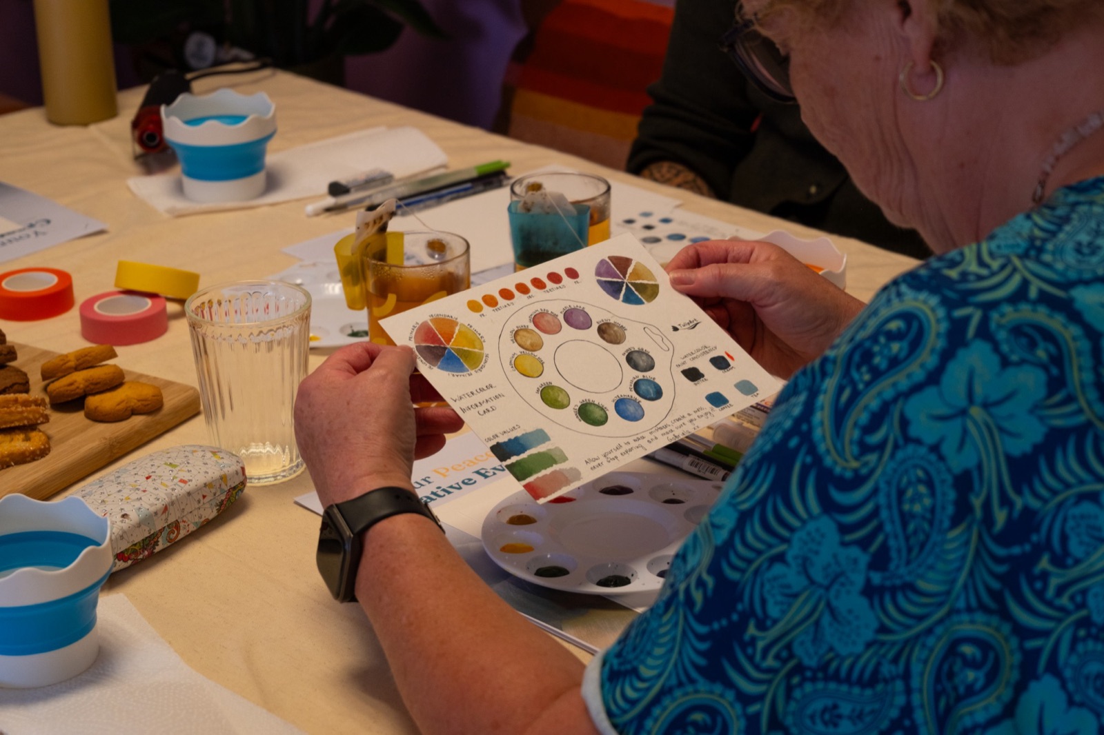 A participant holding the hand-painted watercolour information card with colour wheels