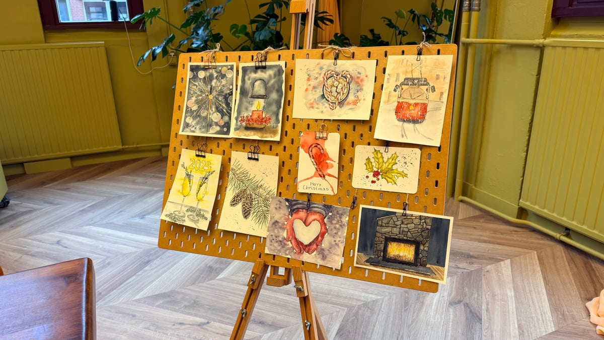 An easel displaying a collection of hand-painted ink and watercolour Christmas cards