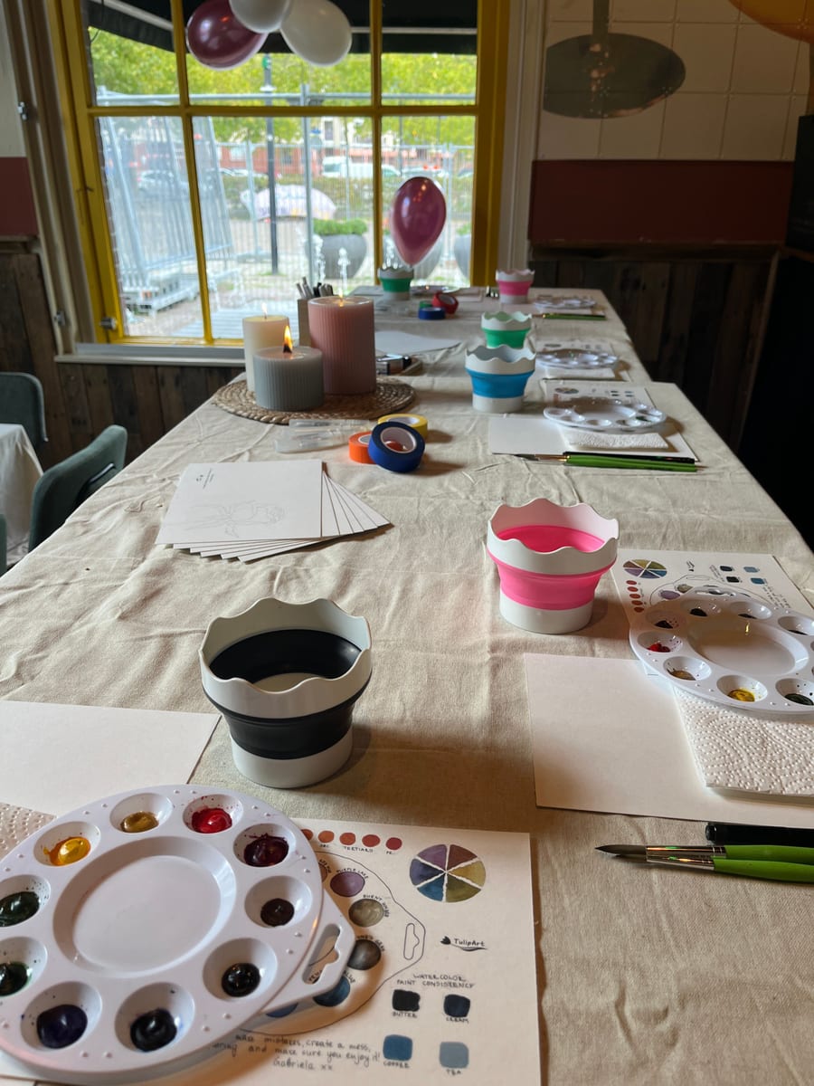 A table set with palettes, brushes and paper before a private workshop begins